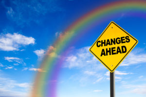 Changes Ahead sign against a blue sky with rainbow. Concept of situation change for the better.