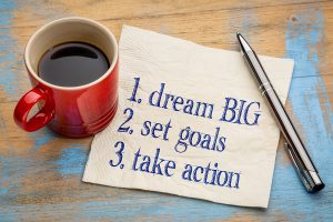 dream big, set goals, take action - inspirational handwriting on a napkin with a cup of coffee